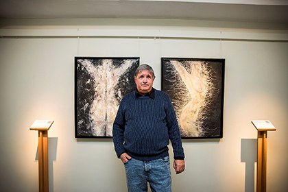 XavierE, entre dos de los cuadros que expone en el Museo Tiflológico de la ONCE